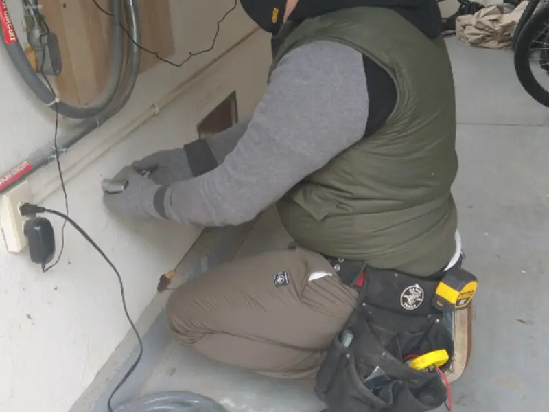 Electrician performing outlet wiring in a Highland Falls garage